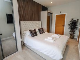 A bedroom with a bed and decorative pillows at The Joiners Cottage Birling near Warkworth
