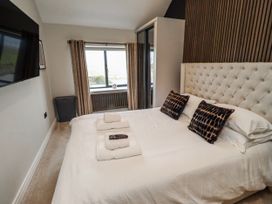 A bedroom with a bed and television at The Joiners Cottage in Birling near Warkworth