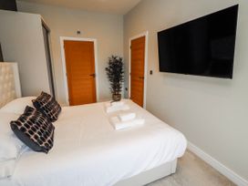 A bedroom with a bed and television at The Joiners Cottage in Birling near Warkworth