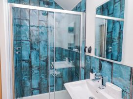 A bathroom with shower and sink at The Joiners Cottage in Birling near Warkworth