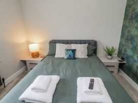 A bedroom with a bed and lamp at The Joiners Cottage in Birling near Warkworth