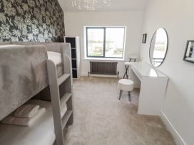 A bedroom with a bunk bed and desk at The Joiners Cottage in Birling near Warkworth