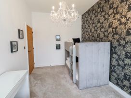 A bedroom with shelves and a chandelier at The Joiners Cottage in Birling near Warkworth