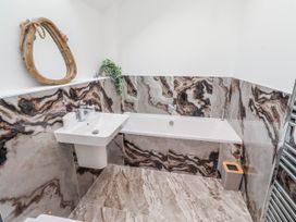 A bathroom with a bathtub and sink at The Joiners Cottage in Birling near Warkworth