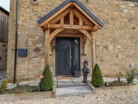 An entrance with a door, statue, and plants at The Joiners Cottage in Birling near Warkworth
