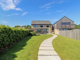 A view of two houses with a pathway in the garden at The Joiners Cottage in Birling near Warkworth
