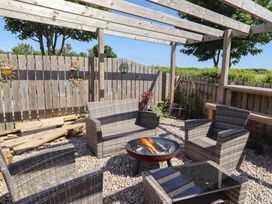 An outdoor seating area with a fire pit and gravel surface at The Joiners Cottage in Birling near Warkworth