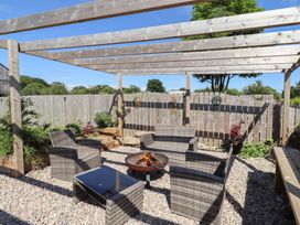 A garden with a seating area and fire pit at The Joiners Cottage in Birling near Warkworth