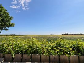 A view of a field and sky from a wooden fence at The Joiners Cottage in Birling near Warkworth