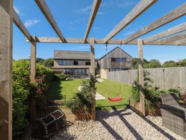 A garden with a swing and pathway at The Joiners Cottage in Birling near Warkworth