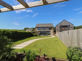 A garden with a lawn and pathway at The Joiners Cottage in Birling near Warkworth