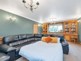 A living room with a large sofa and bookshelf at Oldfields