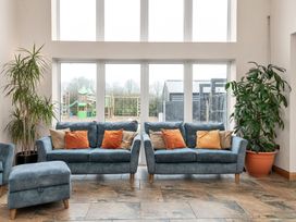 A living room with sofas and a view of a playground at Oldfields