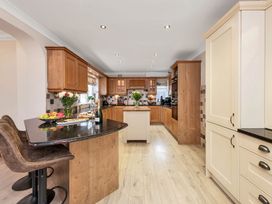 A kitchen with an island and bar stools at Oldfields
