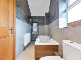 A bathroom with a bath tub and toilet at Oldfields