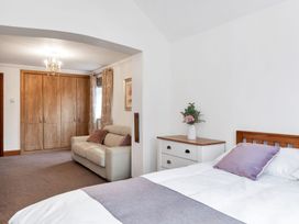 A bedroom with a bed, sofa, and wardrobe at Oldfields