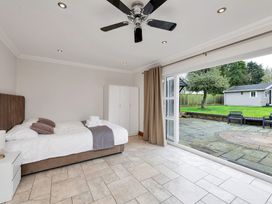 A bedroom with a bed and sliding door access to the outside at Oldfields