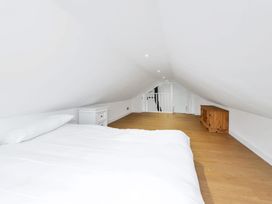 A loft with a bed, nightstand, and wooden chest at Oldfields