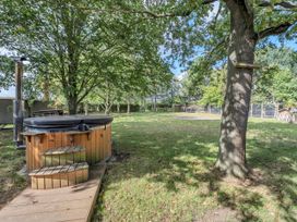An outdoor area with a hot tub and trees at Oldfields in Bury St Edmunds