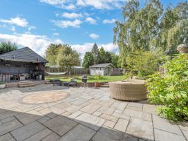 An outdoor patio with seating and a garden shed at Oldfields in Bury St Edmunds