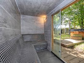 A sauna with bench and glass door at Oldfields Bury St Edmunds