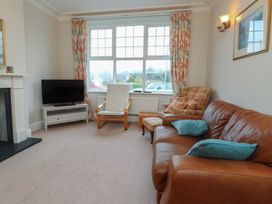 A living room with a sofa and television at Bryniau in Pwllheli