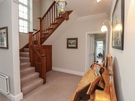 A hallway with a staircase and console table at Bryniau in Pwllheli