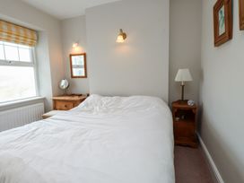 A bedroom with a bed and mirror at Bryniau in Pwllheli