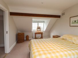 A bedroom with a bed, mirror, and wicker basket at Bryniau in Pwllheli