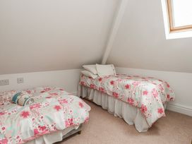 A bedroom with two beds and a window at Bryniau in Pwllheli