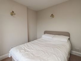 A bedroom with a bed and light fixtures at Bryniau Pwllheli