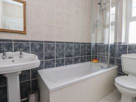 A bathroom with sink, bathtub, shower, and toilet at Bryniau in Pwllheli