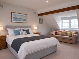 A bedroom with a bed and a couch at Bryniau in Morfa Nefyn