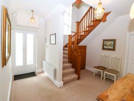 A hallway with stairs and a table at Bryniau in Morfa Nefyn