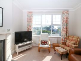 A living room with a television and armchair at Bryniau Morfa Nefyn