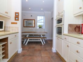 A kitchen with a dining table and appliances at Bryniau in Morfa Nefyn