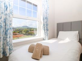 A bedroom with a bed and window at Bryniau Morfa Nefyn