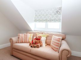 A snug with a sofa and teddy bear at Bryniau in Morfa Nefyn