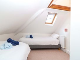 A bedroom with two single beds and a window at Bryniau in Morfa Nefyn