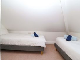 A bedroom with two single beds and towels at Bryniau in Morfa Nefyn