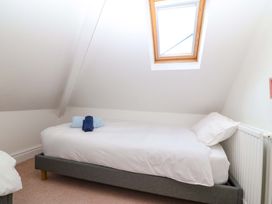 A bedroom with a single bed and a window at Bryniau in Morfa Nefyn