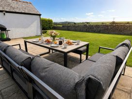 An outdoor seating area with a table set for breakfast at Bryniau in Morfa Nefyn