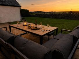 An outdoor seating area with drinks and snacks at Bryniau, Morfa Nefyn