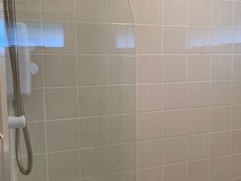 A shower area with tiled walls and a glass partition at 187 Atlantic Bays Tregolds