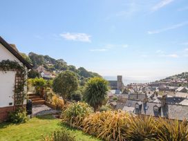 A view of a house with a garden and sea in the background at Devona Beer