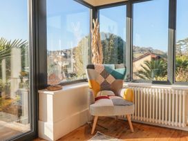 A conservatory with a chair and a decorative object at Devona in Beer