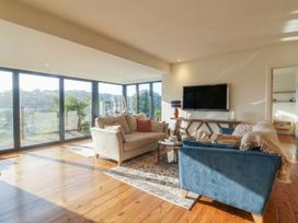 A living room with a television and large windows at Devona in Beer