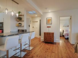 A kitchen with bar stools and a console table at Devona in Beer