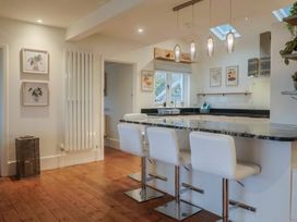 A kitchen with an island and bar stools at Devona in Beer
