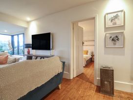 A living room with a television and a doorway to a bedroom at Devona in Beer